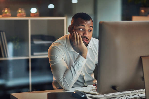 Frustrated person working late at computer, representing tedious manual marketing tasks